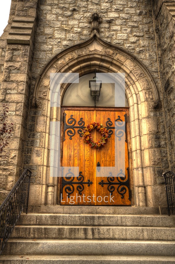 wreath on wood doors on a stone cathedral 