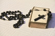 Rosary prayer beads on an old Bible 