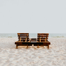 wooden lounge chairs on a beach 