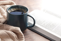 coffee cup and sweater with open Bible 