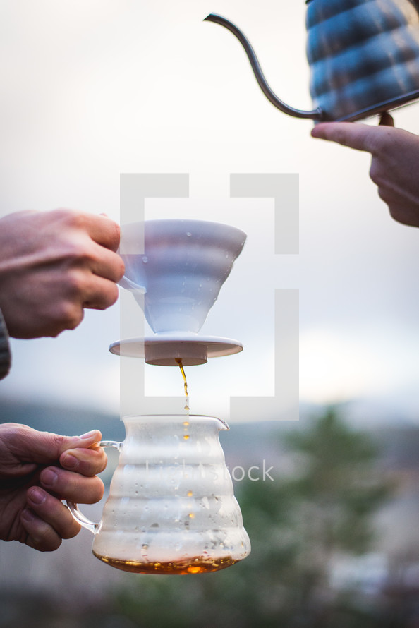 pouring and filtering coffee outdoors 