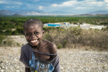 smiling little boy with torn clothing 