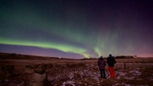people watching an aurora in the sky