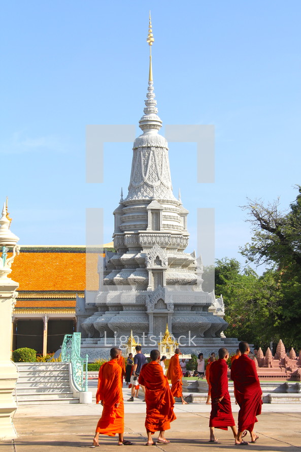 Buddhist monks walking in front of a temple 