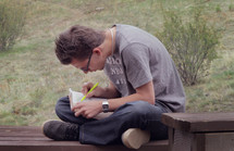 man highlighting scripture outdoors 