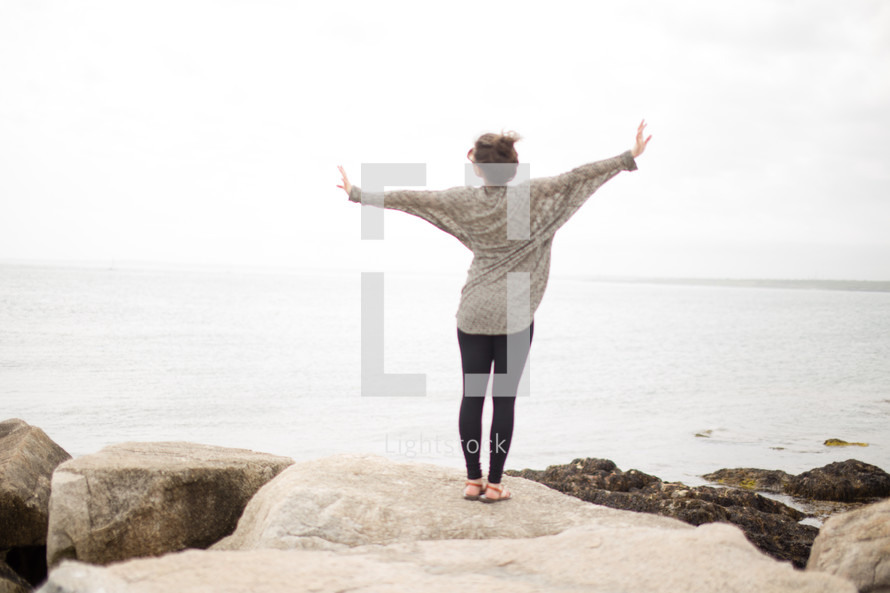 woman standing with open arms enjoying nature 