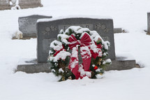 Christmas wreath in snow on a grave 