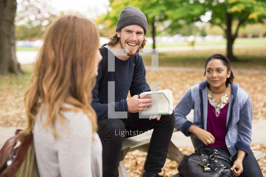students having a Bible study at a picnic table 