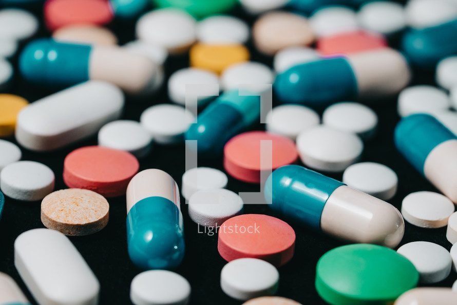Pharmacy theme. Multicolored Isolated Pills and Capsules on Black Surface. Vitamins, drugs concept. COVID-19, Coronavirus, epidemic. High quality photo