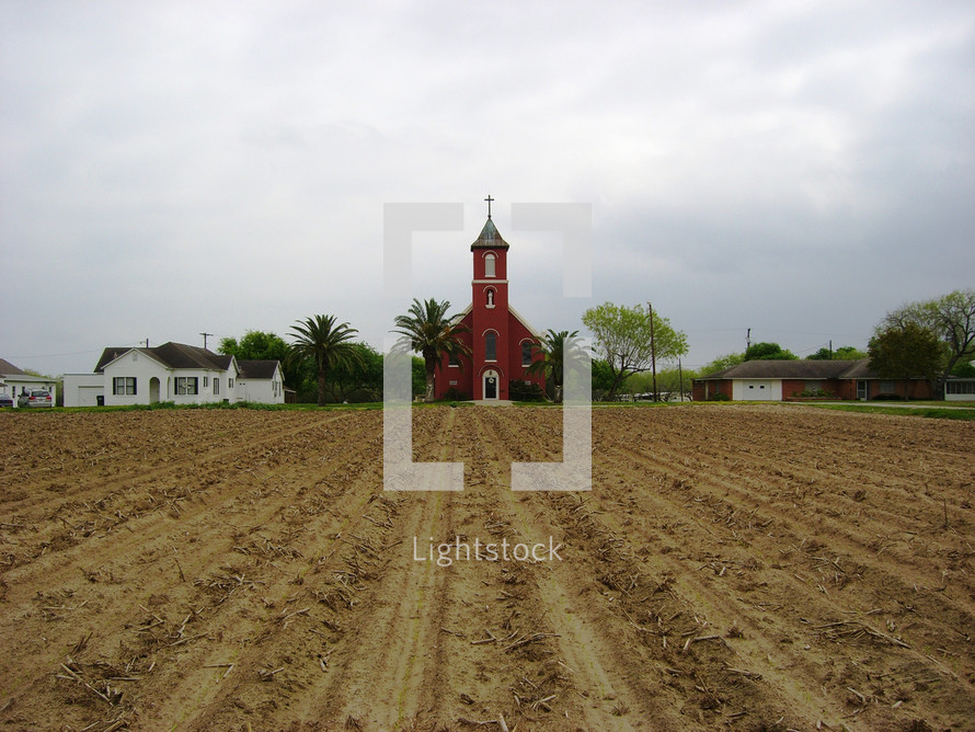 red church and plowed field 