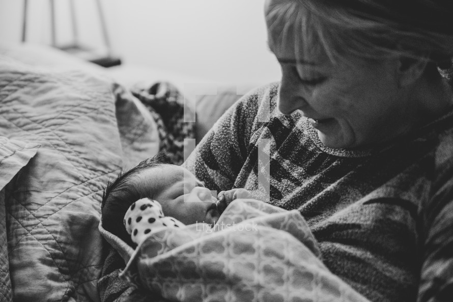 Grandmother holding newborn baby and smiling - black and white