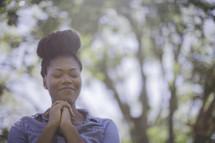 An African American woman with praying hands 