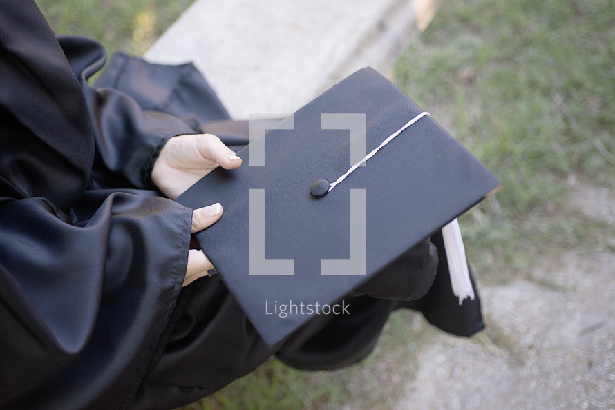 a graduate holding her graduation cap 