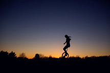 silhouette of a woman on a unicycle 