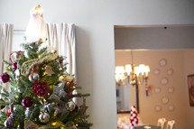 Decorated Christmas tree with lights with dining table in the background