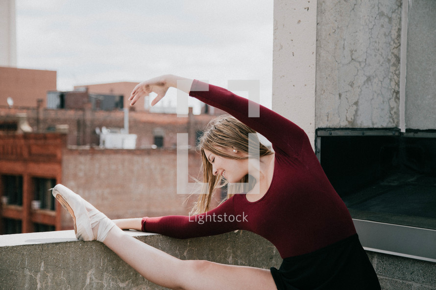 ballerina stretching on a rooftop 