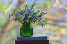 Spring Colorful Flowers in Vase on Books near Window