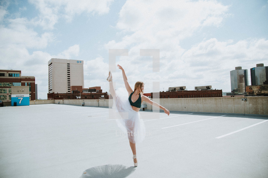 a ballerina on a parking garage roof 