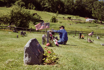 an elderly man visiting a grave on Memorial Day 