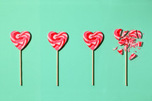 Red and white heart lollipops on a teal background
