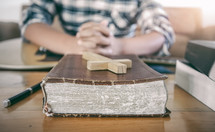 a man with a guitar in his lap praying with a Bible 