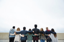 row of teens standing with arms around each other 