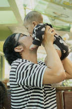 father kissing an infant 