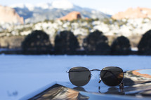 Sunglasses with a lake in the background.