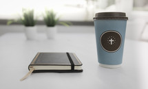 coffee cup with a cross and journal 