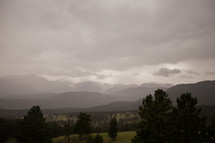 grey clouds over mountains and green hills 