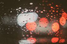 Red and white bokeh through raindrops