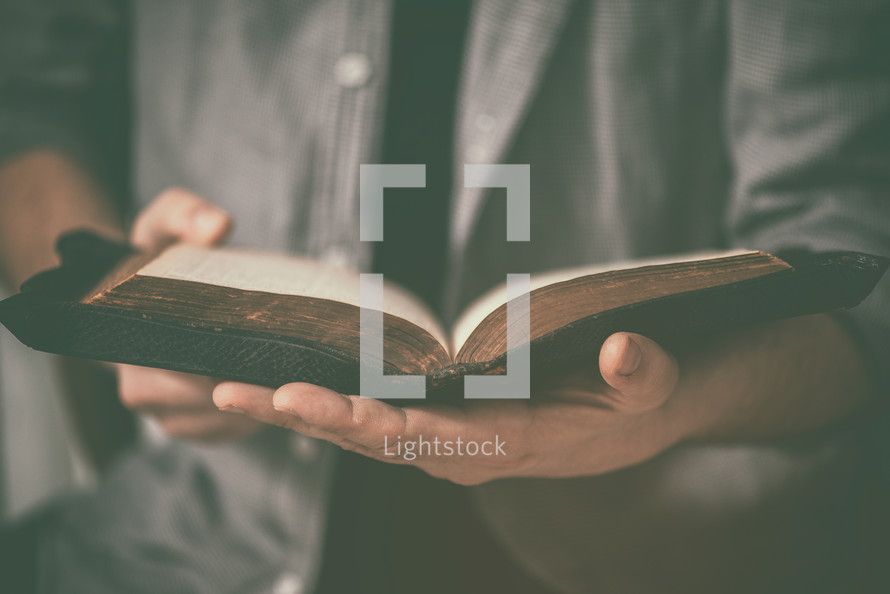a man holding an open Bible 