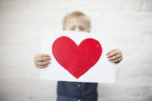 boy holding a painting of a heart 