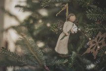 An angel Christmas ornament on a Christmas tree