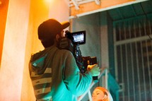 man filming with a video camera 