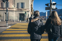 women walking across a crosswalk 