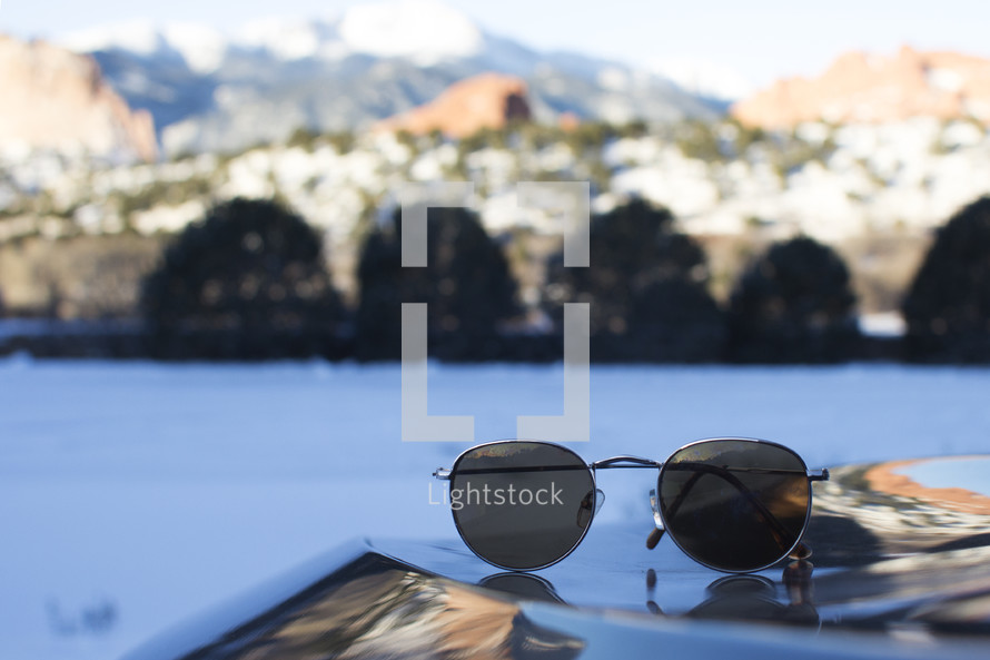 Sunglasses with a lake in the background.