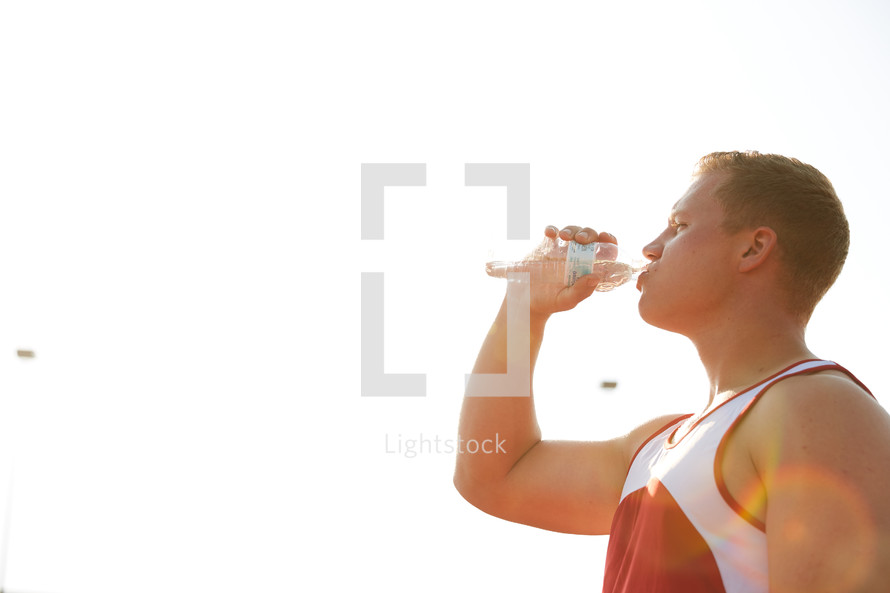 man drinking water at a sports practice 