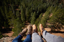 couples boots hanging over a cliff 