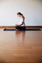 a woman meditating in a yoga studio 