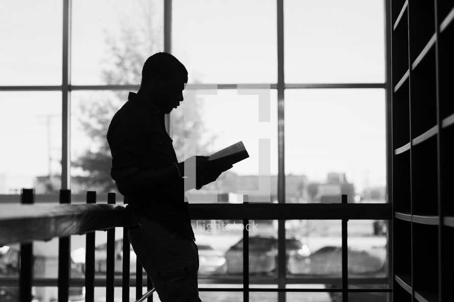 a man picking out books in a library 