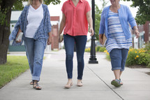 women walking on a sidewalk carrying Bibles 