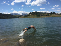 man diving in to a lake 