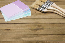 paint brushes and color samples on wood background 