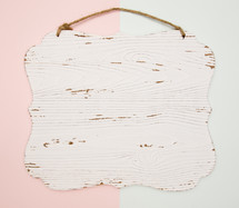 pink and blue background with white wood sign 