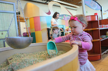 toddler girl playing at a discovery center 