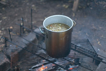 cooking in a pot over a fire 