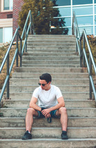 young man sitting on concrete steps 