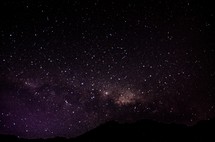 stars in the night sky above mountains