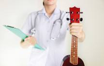 healthcare worker holding a musical instrument 